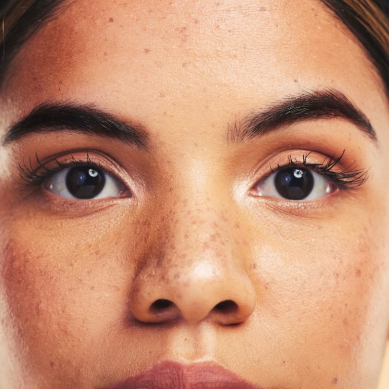 Woman, skin and closeup in studio portrait with beauty, cosmetics and natural glow on face by backg.