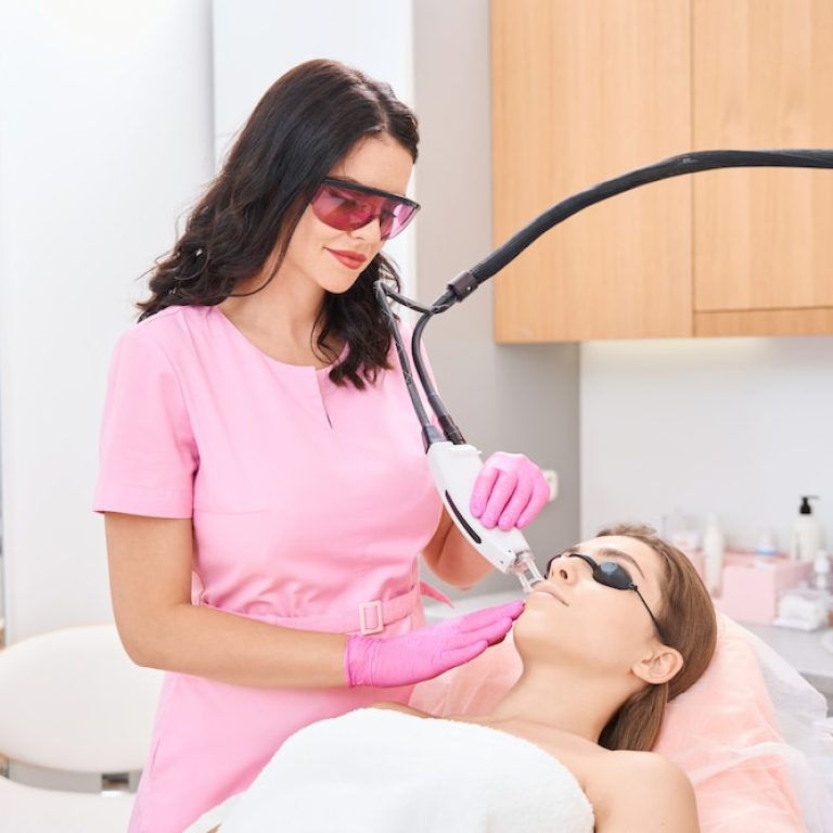 La cosmetóloga realiza un procedimiento de rejuvenecimiento facial con láser en el rostro femenino