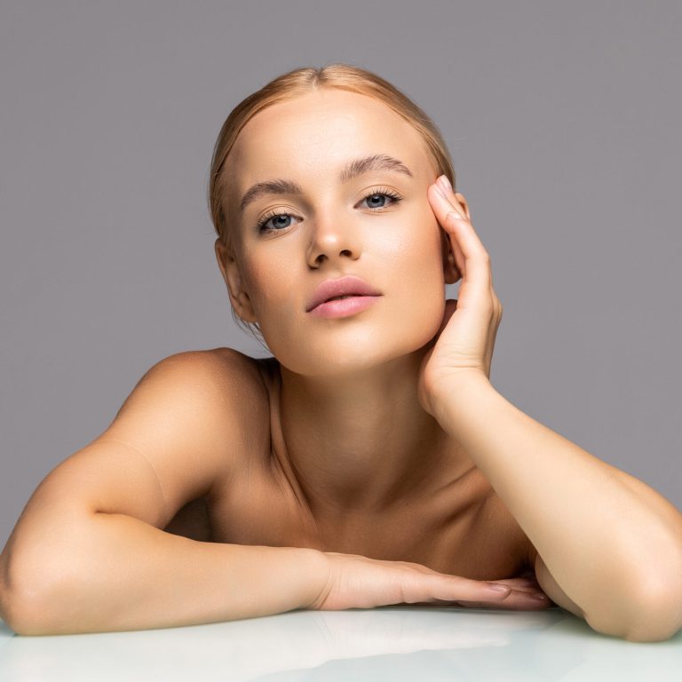 Young woman with beauty skin and beauty hairstyle over gray background